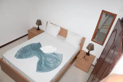 a bedroom with a bed with a green blanket on it at Plateau Bedroom & Chambre - Praia Center 1 in Praia