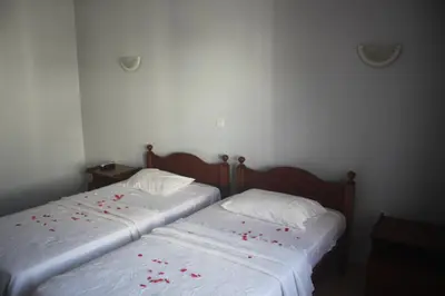 two beds with red rose petals on the sheets at Hotel Avenida in Assomada