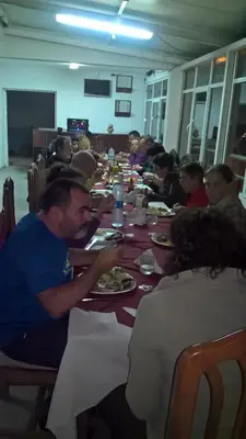 a group of people sitting at a long table eating at Hotel Avenida in Assomada