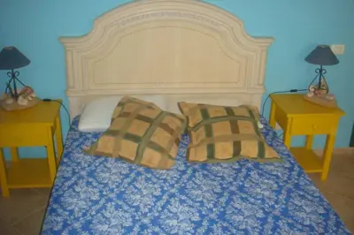a bedroom with a large bed with two nightstands and two tables at Kasa Mona in Calheta Do Maio