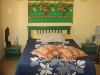 a bedroom with a bed with a blue blanket and pillows at Akwaba chambre double et salle de bain privative in Morro