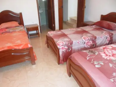 a bedroom with two beds and a table and chairs at Casa Celeste in Ponta do Sol