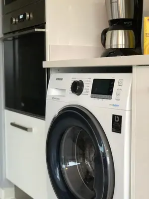 a washing machine in a kitchen with a microwave at Harmony apartment in Mindelo São Vicente in Mindelo