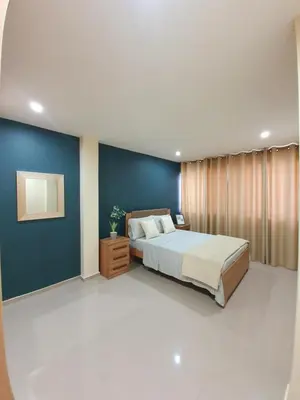 a bedroom with a bed and a blue wall at kelly's House Plateau City Center in Praia