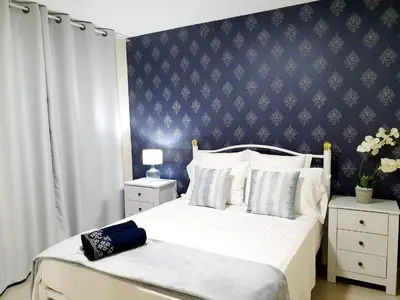 a bedroom with a large bed with a blue wall at kelly's House Plateau City Center in Praia