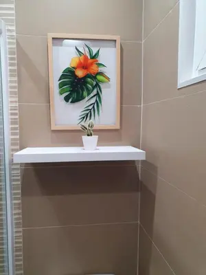 a picture of a flower on a shelf in a bathroom at kelly's House Plateau City Center in Praia