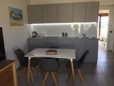 a kitchen with a table and chairs and a counter at Apt71 Porto Antigo 2 in Santa Maria