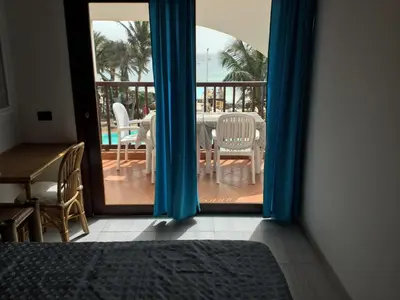 a room with a door open to a patio with a table and chairs at Apt71 Porto Antigo 2 in Santa Maria