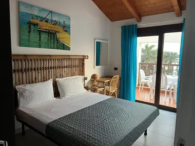 a bedroom with a bed and a view of a deck at Apt71 Porto Antigo 2 in Santa Maria