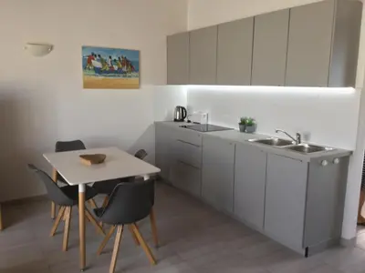 a kitchen with a sink and a table with chairs at Apt71 Porto Antigo 2 in Santa Maria