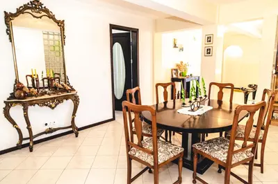 a dining room with a table and chairs and a mirror at Criola Vistamar in Mindelo