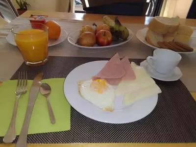 a table with two plates of food and a drink at Criola Vistamar in Mindelo