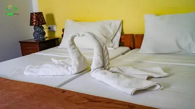 a bed with two towels shaped like swans on it at Pousada Green Place in Ribeira Grande
