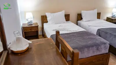 a small room with two beds and a table and a table sidx sidx at Pousada Green Place in Ribeira Grande