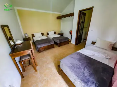 a bedroom with two beds and a desk and a mirror at Pousada Green Place in Ribeira Grande