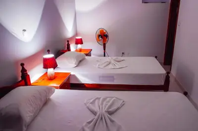 two beds in a bedroom with two lamps and a mirror at Pousada Green Place in Ribeira Grande