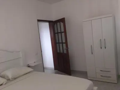 a bedroom with a bed and a wooden door at Apartamento Coral in Santa Maria