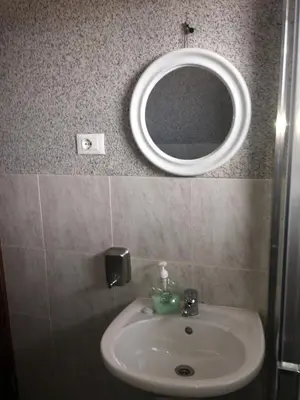 a bathroom with a sink and a mirror on the wall at Apartamento Coral in Santa Maria