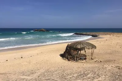 a beach with an umbrella on the sand at Schönes, ruhiges und geräumiges Apartment mit Poolanlage in der Nähe von Santa Maria in Prainha