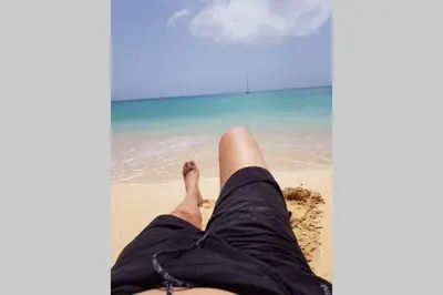 a person laying on the sand at the beach at Schönes, ruhiges und geräumiges Apartment mit Poolanlage in der Nähe von Santa Maria in Prainha