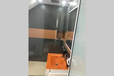 a bathroom with an orange sink and a toilet at Studio GARAGE in Mindelo