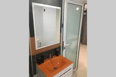 a bathroom with a orange sink and a mirror at Studio GARAGE in Mindelo