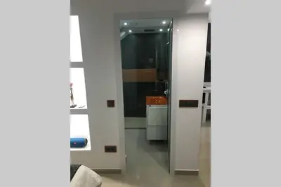 a bathroom with a glass door and a sink at Studio GARAGE in Mindelo