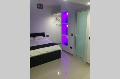 a bedroom with a bed with purple lights on it at Studio GARAGE in Mindelo