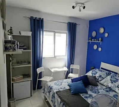 a blue bedroom with a bed and a window at Deluxe B&B 