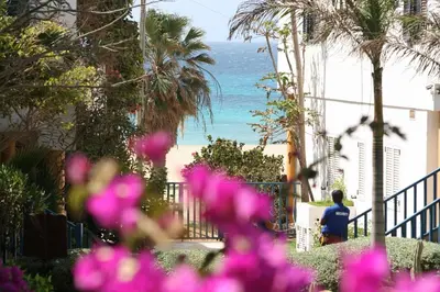 a person walking down a sidewalk next to the beach at Leme Bedje fronte spiaggia in Santa Maria