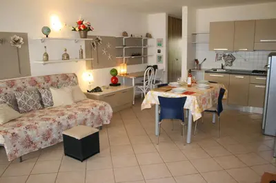 a living room and kitchen with a table and a couch at Leme Bedje fronte spiaggia in Santa Maria