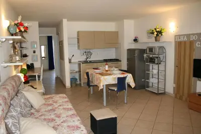 a living room with a table and a kitchen at Leme Bedje fronte spiaggia in Santa Maria
