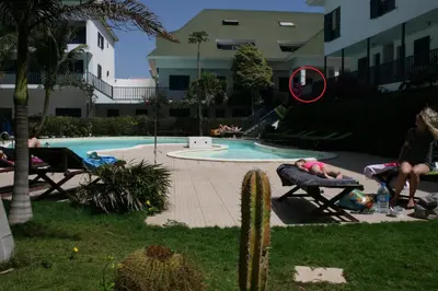 a person sitting on a bench next to a swimming pool at Leme Bedje fronte spiaggia in Santa Maria