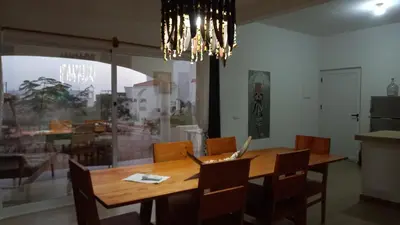 a dining room table with chairs and a chandelier at Casa Djarmai Apartments in Vila do Maio