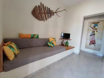 a living room with a couch and a picture on the wall at Casa Djarmai Apartments in Vila do Maio