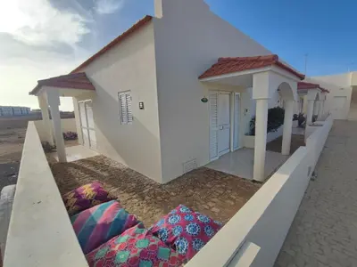 a small white house with pillows in front of it at Casa Djarmai Apartments in Vila do Maio