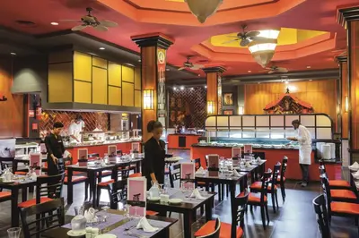 a restaurant with tables and people working in the kitchen at Hotel Riu Funana - All Inclusive in Santa Maria