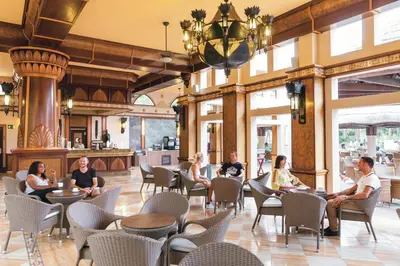 a group of people sitting in chairs in a lobby at Hotel Riu Funana - All Inclusive in Santa Maria