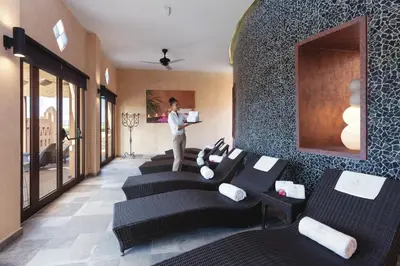 a man standing in a room with a row of black chairs at Hotel Riu Funana - All Inclusive in Santa Maria