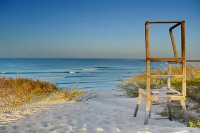 a wooden chair sitting in the sand on the beach at Ca' Santa Barbara, Free Wi-fi, Sea view, Sal Rei, Boa Vista, Cape Verde in Sal Rei