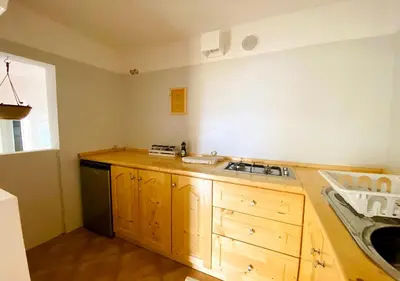 a kitchen with wooden cabinets and a sink in it at Ca' Santa Barbara, Free Wi-fi, Sea view, Sal Rei, Boa Vista, Cape Verde in Sal Rei