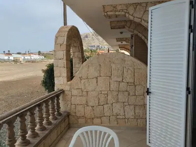 a white chair sitting on a balcony next to a door at Comfortable and spacious apartment with ocean views of Cabral beach in Sal Rei