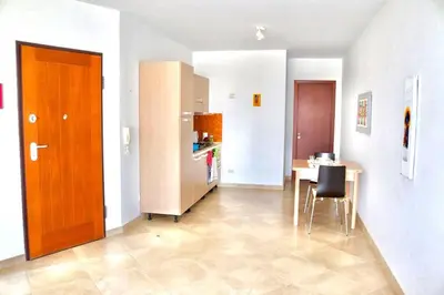 a room with a kitchen with a table and a refrigerator at Comfortable and spacious apartment with ocean views of Cabral beach in Sal Rei