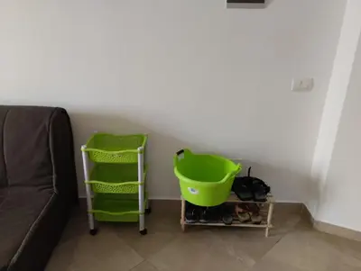 a living room with a green basket next to a couch at Comfortable and spacious apartment with ocean views of Cabral beach in Sal Rei