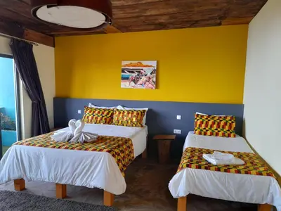 two beds in a room with a yellow wall at THE RETREAT in Monte Joana