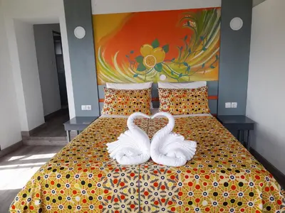 two white swans are sitting on a bed at THE RETREAT in Monte Joana