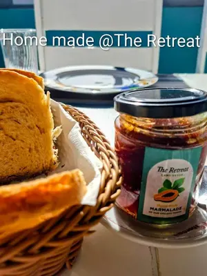 a basket of bread and a jar of jam and a sandwich at THE RETREAT in Monte Joana
