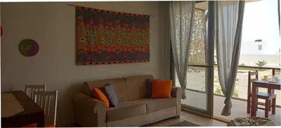 a living room with a couch and a painting on the wall at KatlantiK Ca Madeira Deluxe in Sal Rei