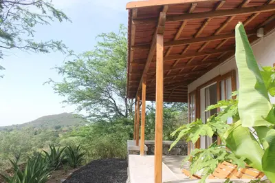 a house with a wooden pergola over a porch at La Fora Ecolodge in São Filipe