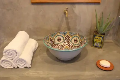 a bathroom with a bowl and towels on a counter at La Fora Ecolodge in São Filipe
